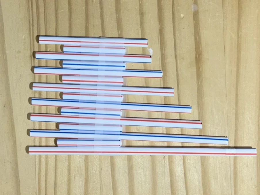 Eight striped straws cut to different lengths and taped into a pan flute